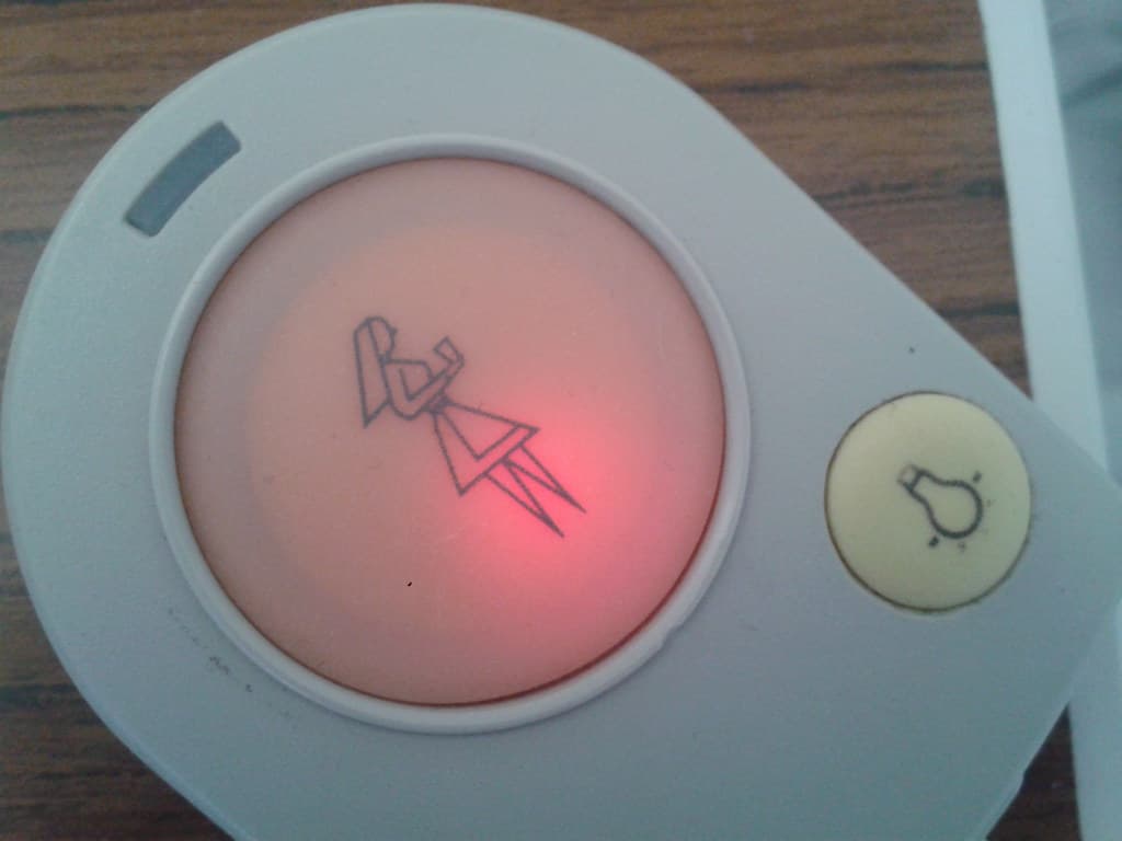 Nurse pressing call button in a hospital room